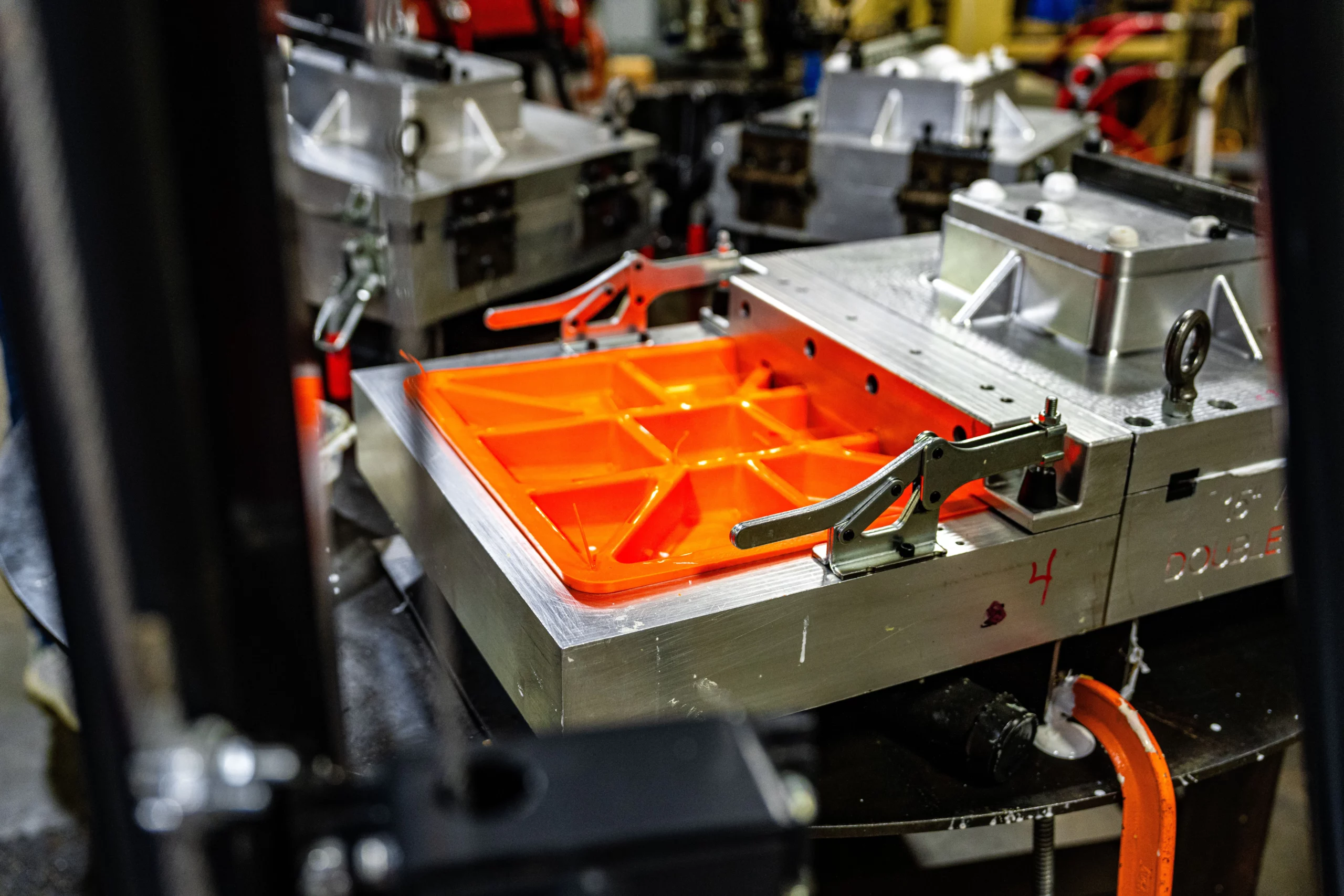 Real Soft Touch base mold with an orange molded base inside the clamped aluminum tooling